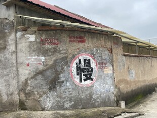 老旧墙面上的   慢  字标识