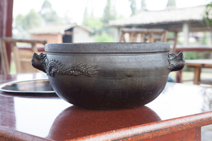 古朴黑陶锅置于木桌