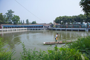 乡村池塘上的竹筏与行人