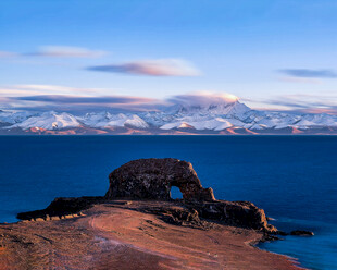 海边残垣与远处雪山美景