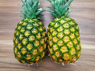 两个新鲜菠萝摆放在木面
