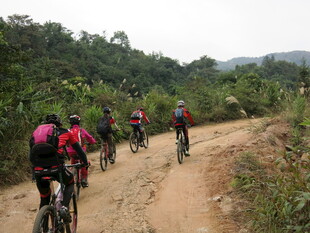 骑行者穿梭于山间土路