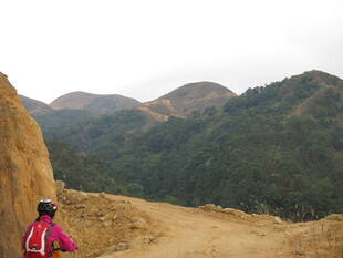 女子骑行于山间土路