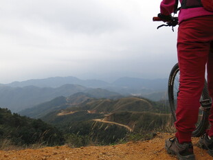 女子骑行于山间远眺美景