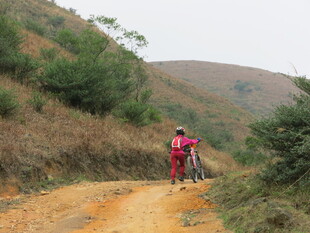 骑行者穿行于山间土路