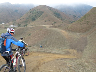 山地骑行者穿梭于山峦间