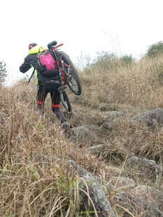 徒步者穿行于山间草丛