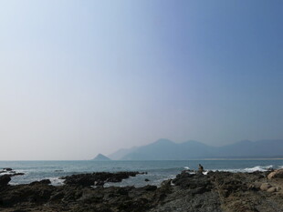 海边礁石与远处山峦美景