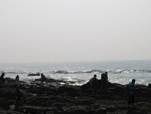 海边礁石上的漫步身影