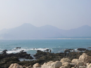 海边礁石与远处山峦景色