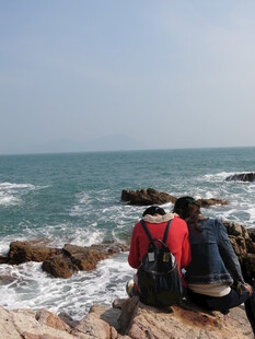 海边礁石上的背包旅行者