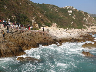 海岸边人群赏汹涌海浪