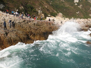 海边礁石处的观浪人群