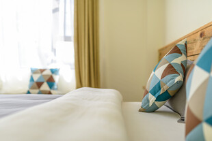 温馨卧室床铺与几何抱枕