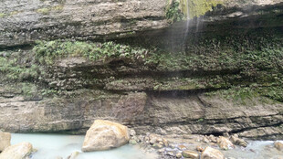 恩施山间瀑布下的岩石与绿植