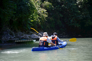恩施两人乘皮划艇于河道中