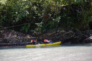 恩施两人泛舟于绿意盎然河岸