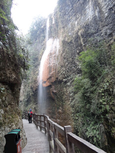 恩施山间栈道旁的壮丽瀑布