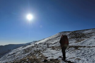 徒步者于雪山向阳而行