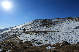 雪覆山坡上的徒步者