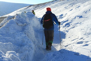 徒步者在雪坡上艰难前行