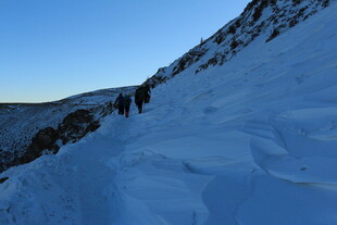 雪地登山者攀登陡峭山坡