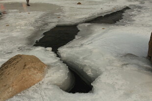 冬日冰面裂缝与石块景象