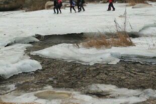 雪地徒步者旁的融冰小溪