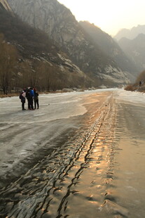 冬日山间结冰道路上的行人