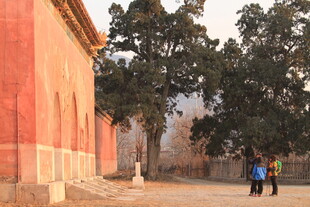 古建红墙下的行人身影