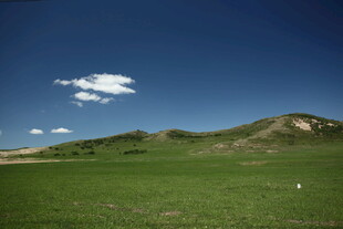 草原蓝天山丘景观图