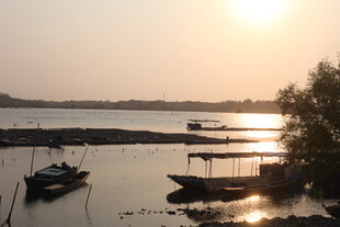 湛江夕阳下宁静的河畔停泊小船