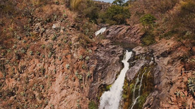 在创造彩虹的红色岩石上的瀑布